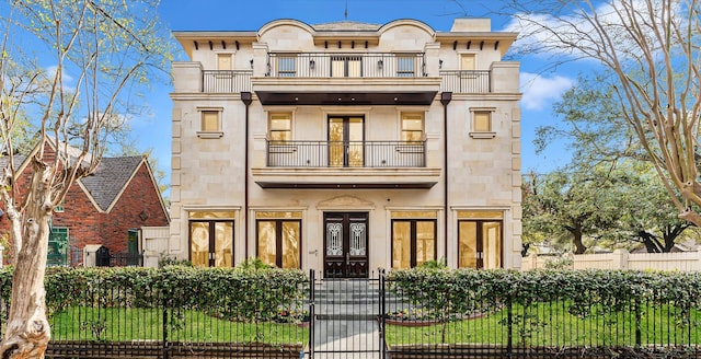 2247 Bartlett St, Houston, TX 77098 - view of front facade featuring a balcony, french doors, a fenced front yard, a gate, and stone siding
