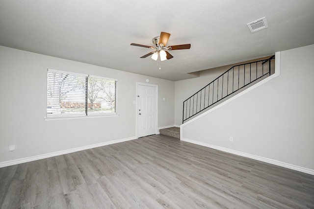 6514 Kentwick Dr, Houston, TX 77084 - unfurnished living room featuring stairs, visible vents, a ceiling fan, and wood finished floors