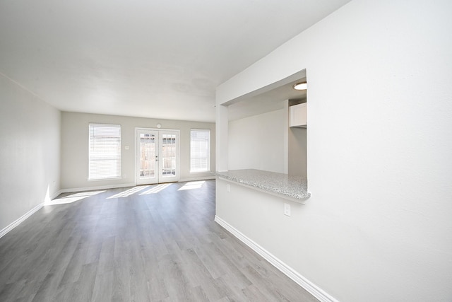 6514 Kentwick Dr, Houston, TX 77084 - unfurnished living room featuring light wood-style floors, baseboards, and french doors