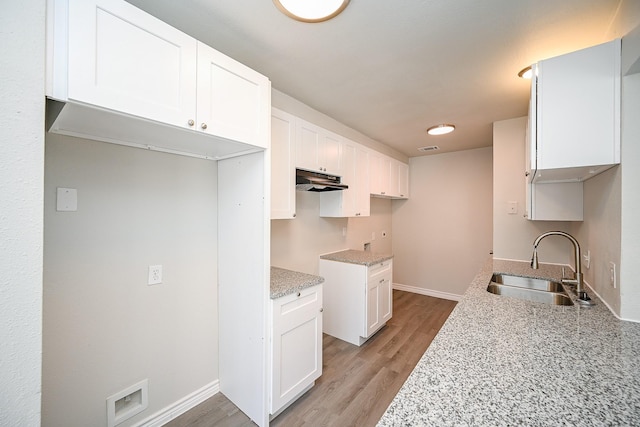 6514 Kentwick Dr, Houston, TX 77084 - kitchen with white cabinets, under cabinet range hood, a sink, and light stone countertops