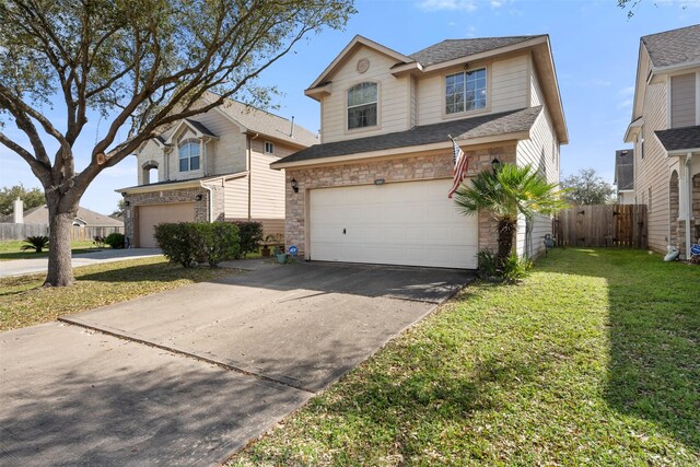 traditional home with fence, concrete driveway, a front lawn, a garage, and stone siding