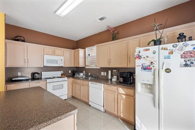 kitchen featuring visible vents, light brown cabinetry, backsplash, dark countertops, and white appliances