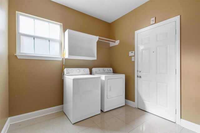 laundry area with washer and dryer, baseboards, laundry area, and light tile patterned floors
