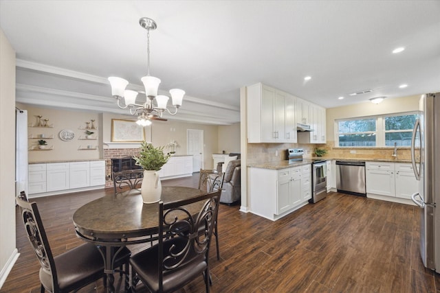 101 Royal Ct, Friendswood, TX 77546 - kitchen with stainless steel appliances, a chandelier, a sink, white cabinets, and recessed lighting