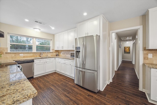 101 Royal Ct, Friendswood, TX 77546 - kitchen featuring appliances with stainless steel finishes, a sink, tasteful backsplash, white cabinets, and recessed lighting