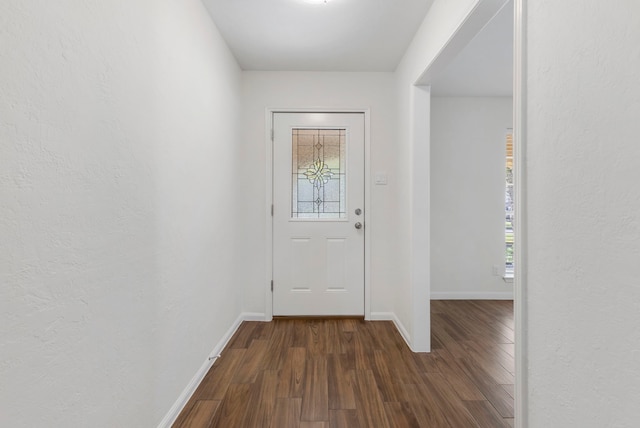 entryway featuring baseboards and dark wood-style flooring