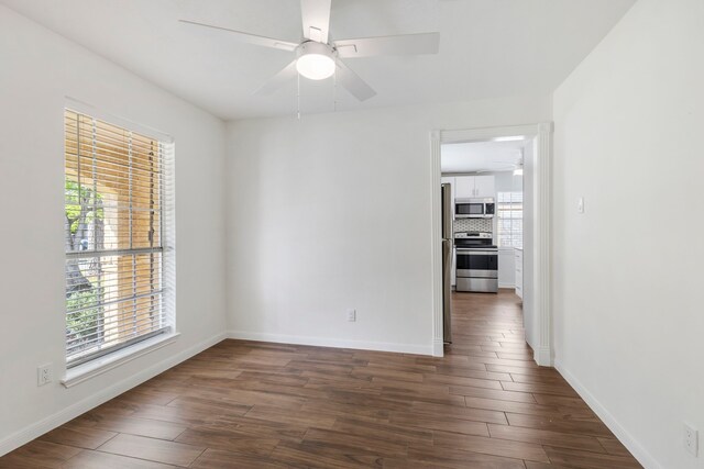 empty room with a ceiling fan, dark wood-style flooring, and baseboards