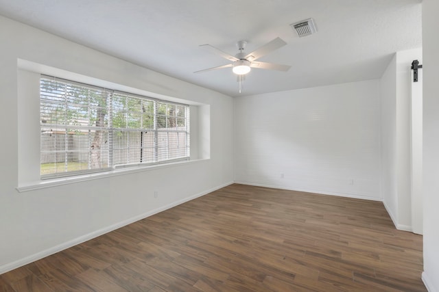 unfurnished room with visible vents, baseboards, ceiling fan, and wood finished floors