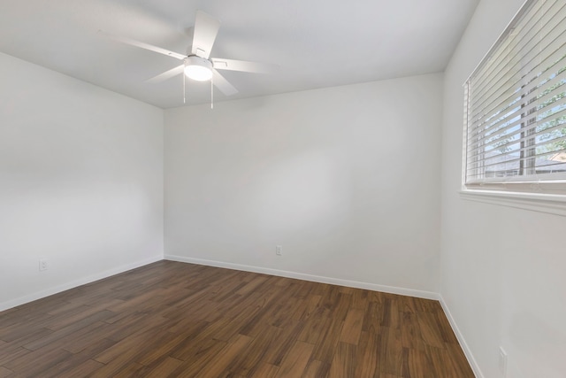 unfurnished room with baseboards, a ceiling fan, and dark wood-style flooring