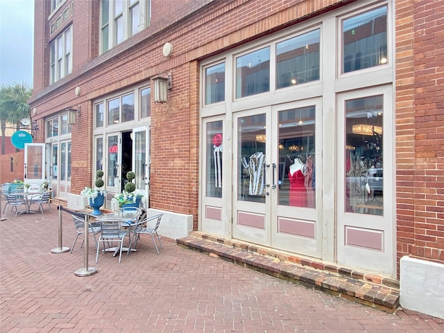 2425 Strand St, Galveston, TX 77550 - view of exterior entry featuring brick siding, outdoor dining area, and french doors