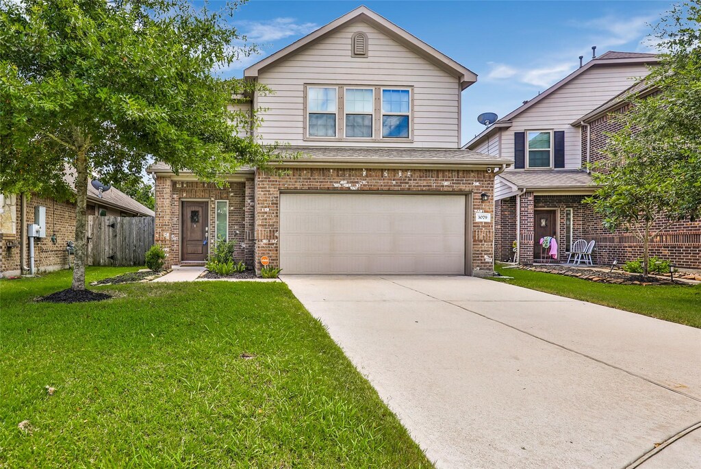 3079 Hawthorne Glen Ln, Dickinson, TX 77539 - traditional-style home with fence, concrete driveway, a front yard, a garage, and brick siding