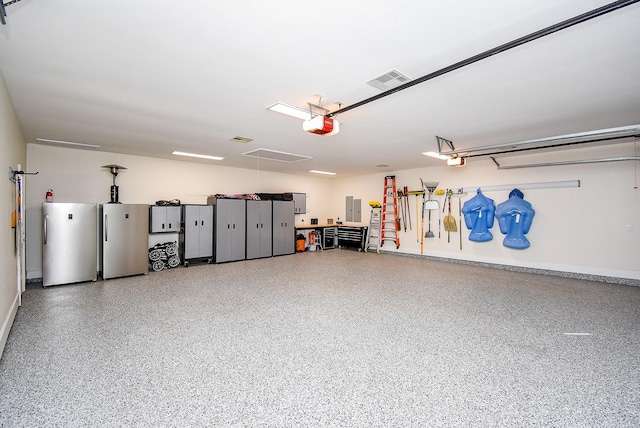 garage featuring electric panel, visible vents, a garage door opener, and freestanding refrigerator