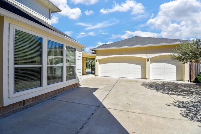 view of side of property featuring an outbuilding, an attached garage, and driveway