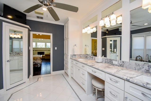 bathroom with a ceiling fan, a sink, connected bathroom, crown molding, and double vanity