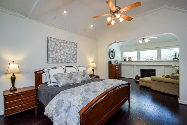 bedroom with arched walkways, lofted ceiling, ornamental molding, and dark wood-style flooring