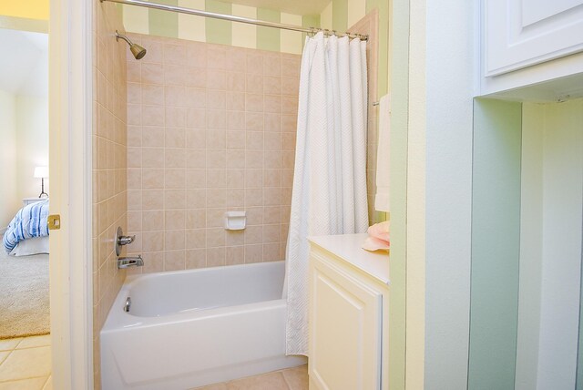 full bathroom with shower / tub combo with curtain and tile patterned flooring