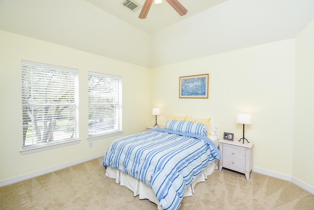 bedroom featuring visible vents, light colored carpet, a ceiling fan, and baseboards