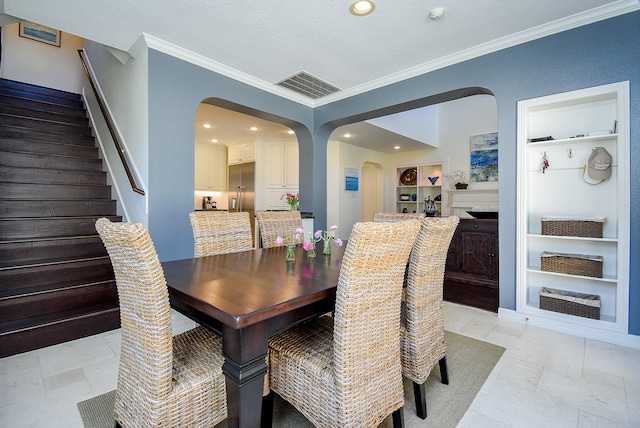 dining space with visible vents, stairway, built in features, arched walkways, and a textured ceiling