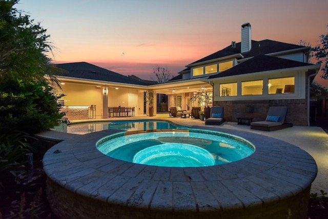 pool featuring an in ground hot tub and a patio