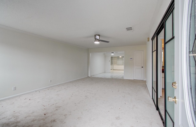 empty room featuring baseboards, light colored carpet, visible vents, and ceiling fan