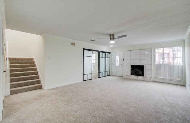 unfurnished living room with carpet flooring, plenty of natural light, a ceiling fan, and crown molding