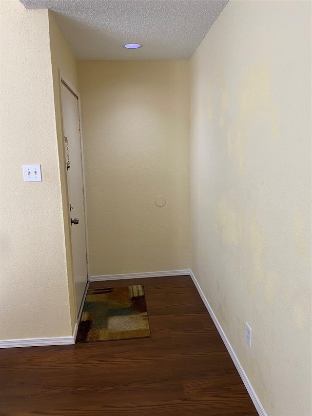 10053 Westpark Dr Unit 306, Houston, TX 77042 - hall featuring wood finished floors, baseboards, and a textured ceiling