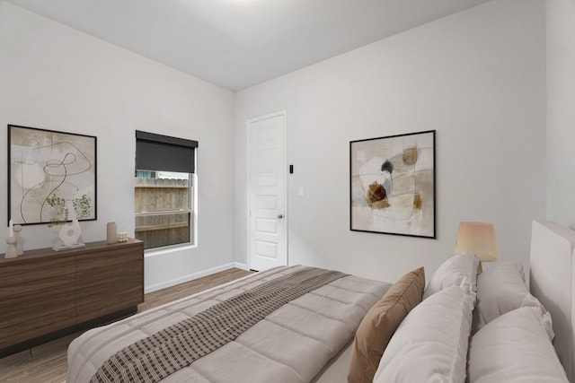 bedroom with baseboards and wood finished floors