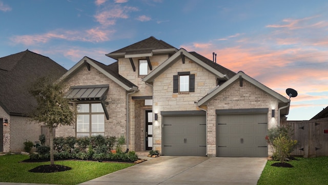 view of front of house with brick siding, a shingled roof, a yard, stone siding, and driveway