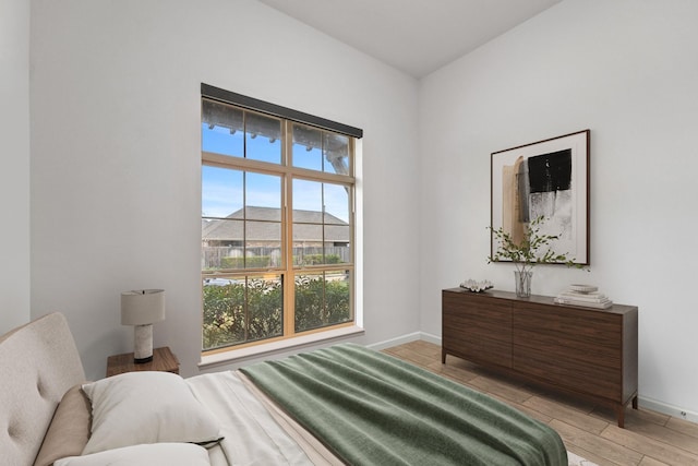 bedroom with light wood-type flooring and baseboards