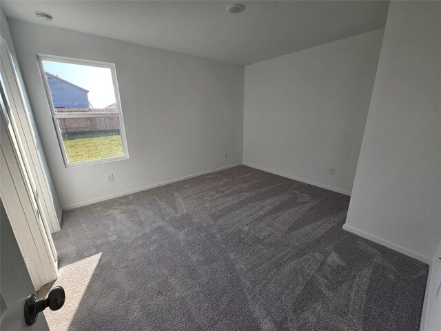 309 Nicholas Rd, Wharton, TX 77488 - unfurnished room featuring dark carpet, baseboards, and a smoke detector