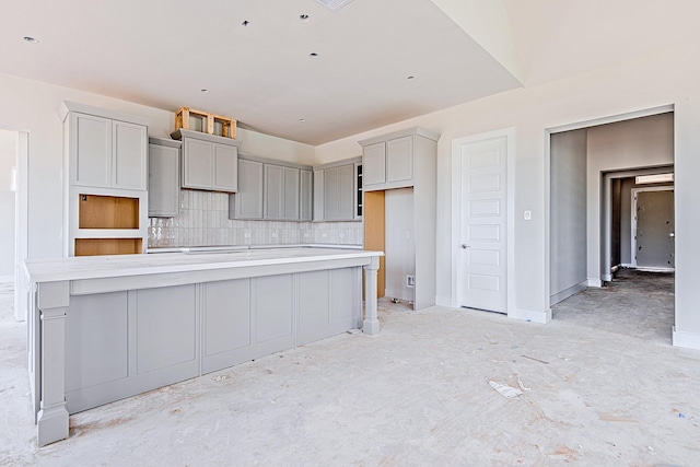 197 Peninsula Point Dr, Montgomery, TX 77356 - kitchen with tasteful backsplash, gray cabinets, a large island, light countertops, and baseboards