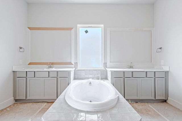 197 Peninsula Point Dr, Montgomery, TX 77356 - bathroom with two vanities, a jetted tub, and baseboards