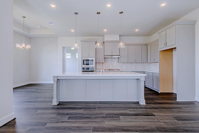 197 Peninsula Point Dr, Montgomery, TX 77356 - kitchen with stainless steel appliances, a chandelier, light countertops, decorative backsplash, and a center island with sink