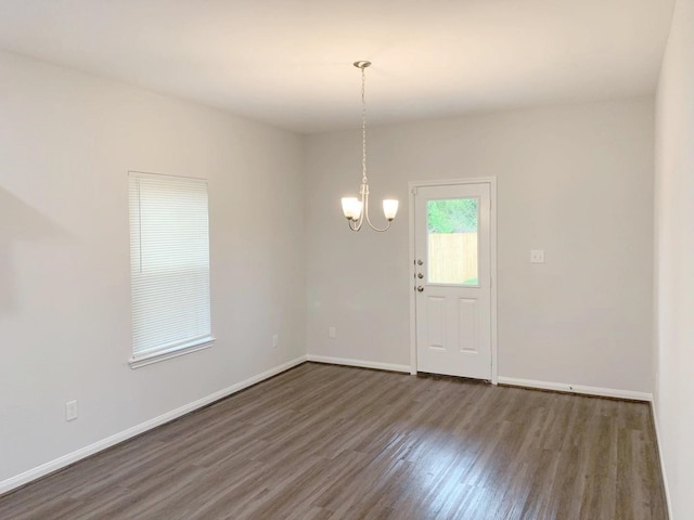 8149 Homewood Ln, Houston, TX 77028 - spare room featuring a chandelier, dark wood-type flooring, and baseboards