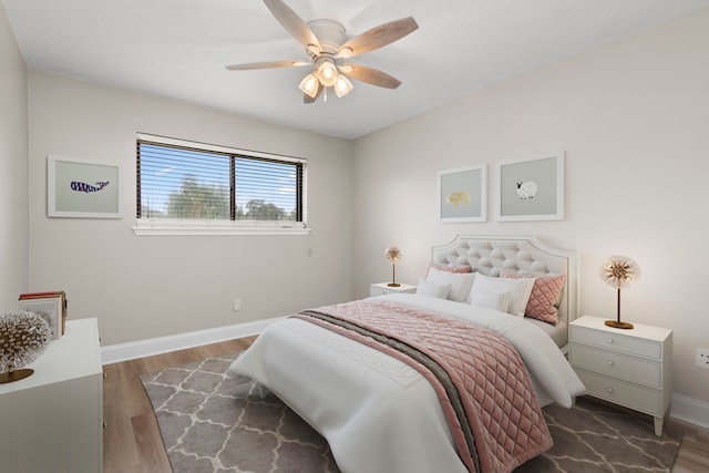 bedroom featuring a ceiling fan, baseboards, and wood finished floors