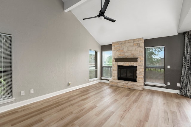 unfurnished living room with wood finished floors, a ceiling fan, baseboards, high vaulted ceiling, and a stone fireplace