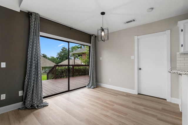 unfurnished dining area featuring visible vents, baseboards, and light wood finished floors