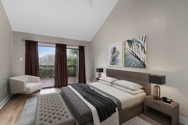 bedroom featuring baseboards, high vaulted ceiling, wood finished floors, and access to outside