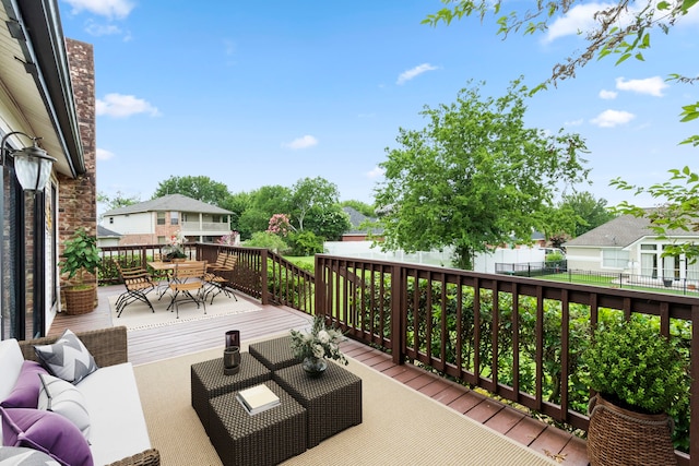 wooden deck with outdoor dining space, outdoor lounge area, and fence
