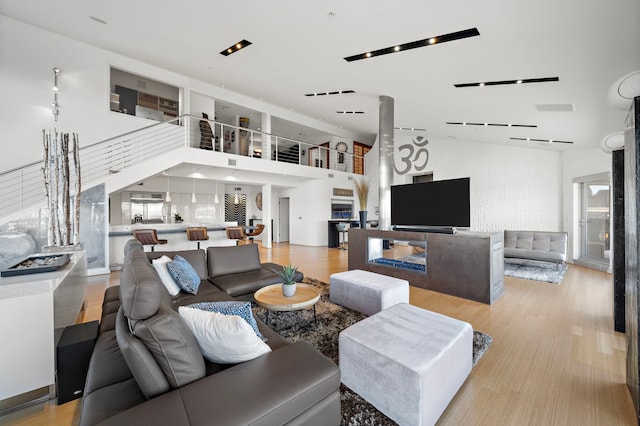 102 Quitman St Unit 405, Houston, TX 77009 - living area featuring stairs, a towering ceiling, wood finished floors, and visible vents