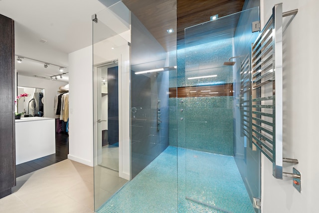 102 Quitman St Unit 405, Houston, TX 77009 - full bathroom featuring a spacious closet, track lighting, a stall shower, and tile patterned floors