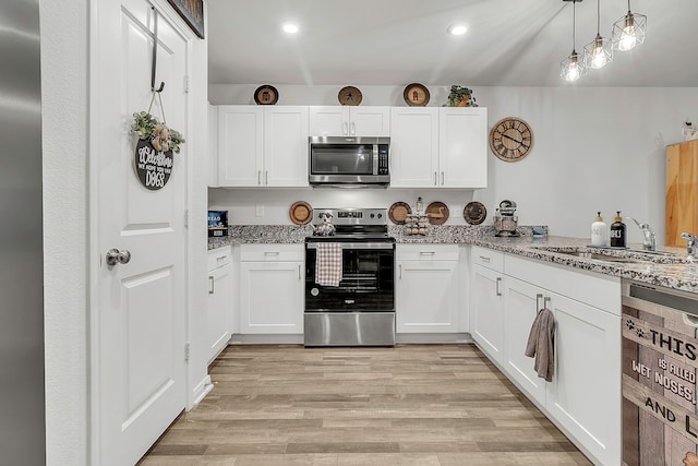 kitchen featuring a sink, stainless steel appliances, light wood-style flooring, and white cabinetry