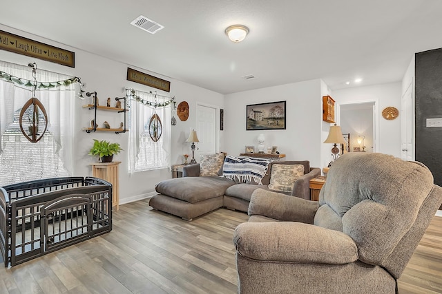 living room with visible vents, recessed lighting, baseboards, and wood finished floors