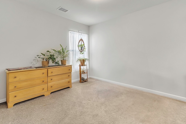 interior space featuring visible vents, light colored carpet, and baseboards