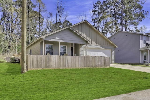 view of front of property featuring board and batten siding, fence, concrete driveway, a front yard, and an attached garage
