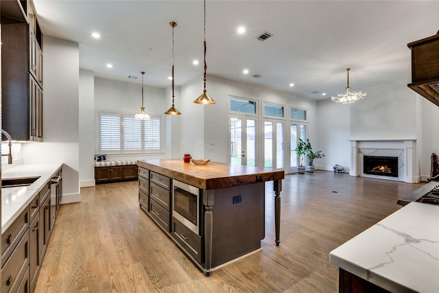 3302 Elmridge St, Houston, TX 77025 - kitchen with a sink, stainless steel microwave, wooden counters, and a chandelier