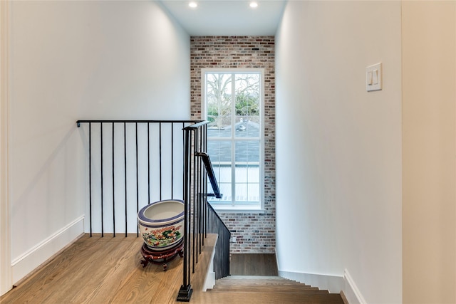3302 Elmridge St, Houston, TX 77025 - stairs featuring recessed lighting, baseboards, wood finished floors, and brick wall
