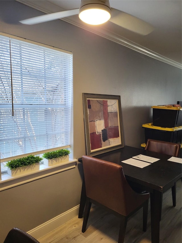 dining space with wood finished floors, a healthy amount of sunlight, and ornamental molding