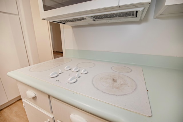 details featuring white electric stovetop, light countertops, and extractor fan