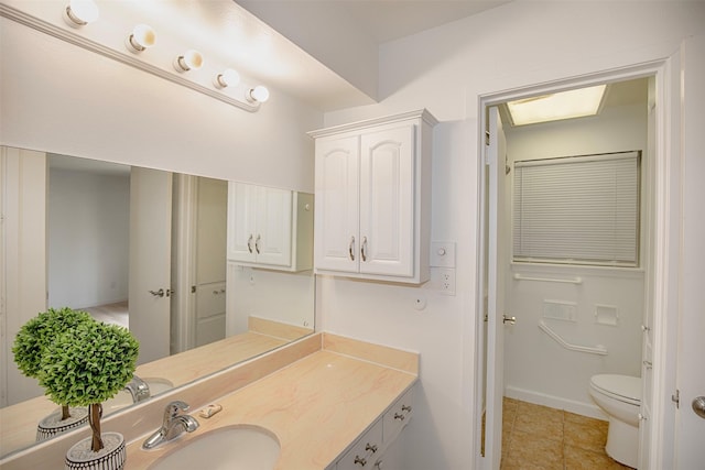 bathroom featuring tile patterned floors, baseboards, vanity, and toilet